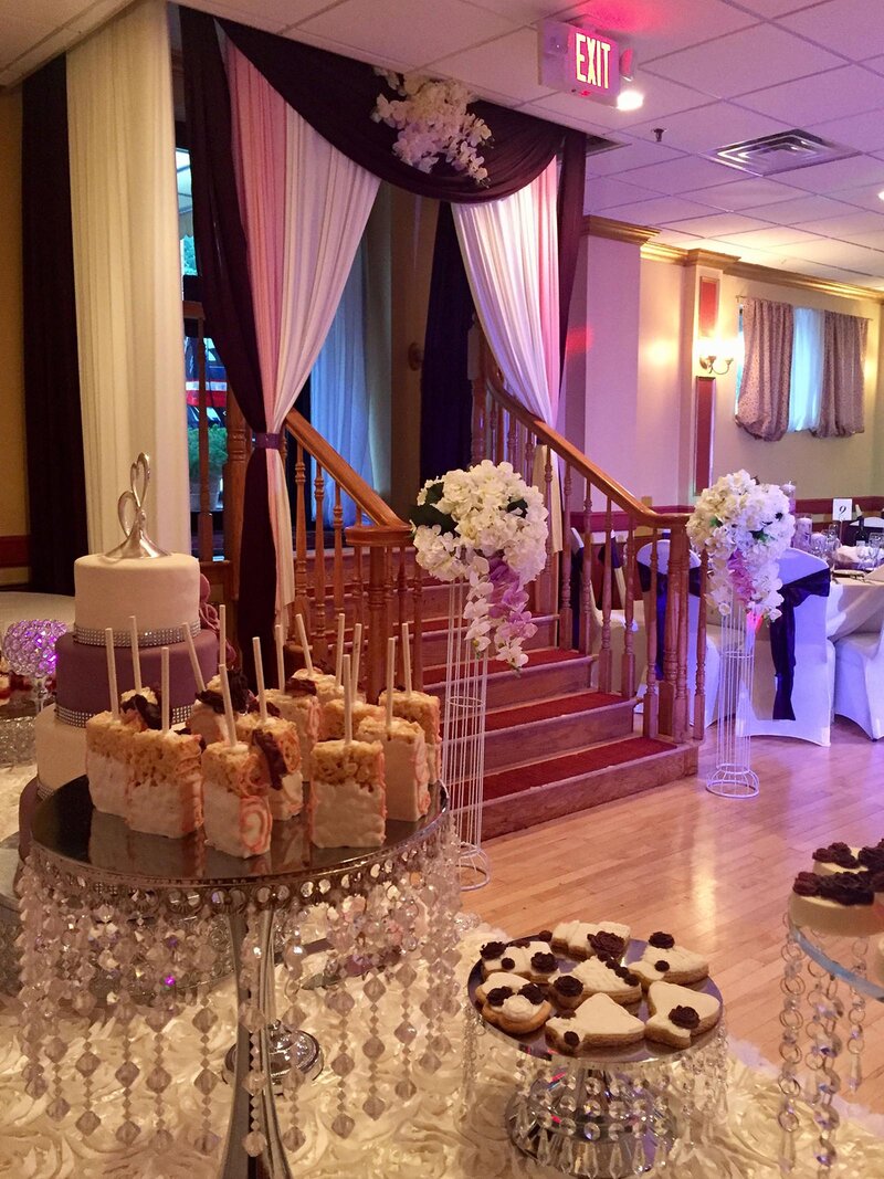 Party room with view of stairs and table with a variety of desserts