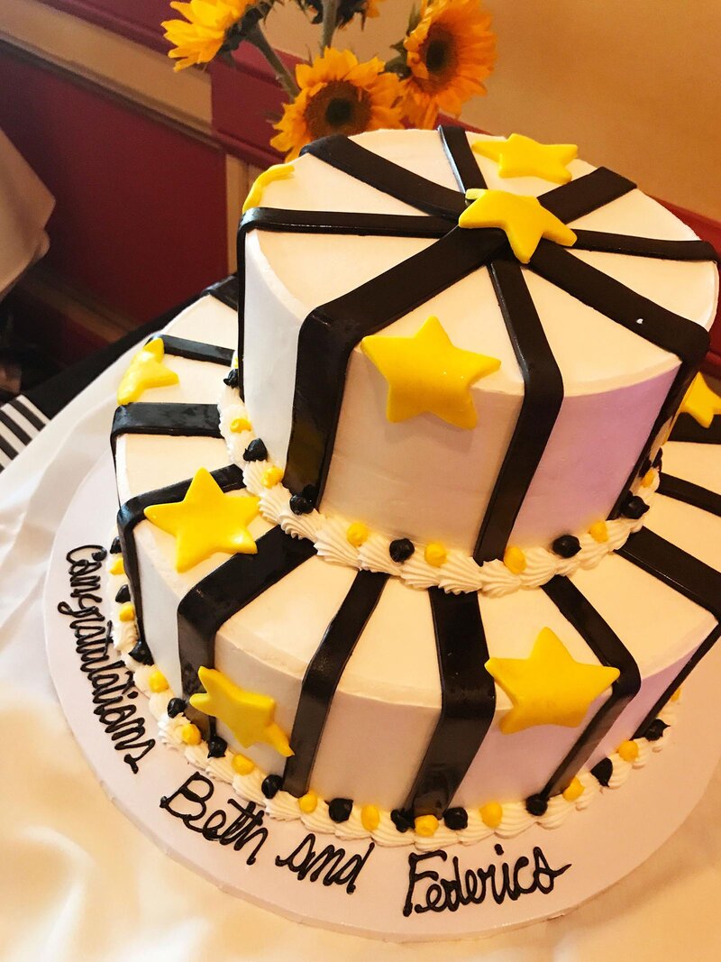 White cake with black and white frosting with yellow stars