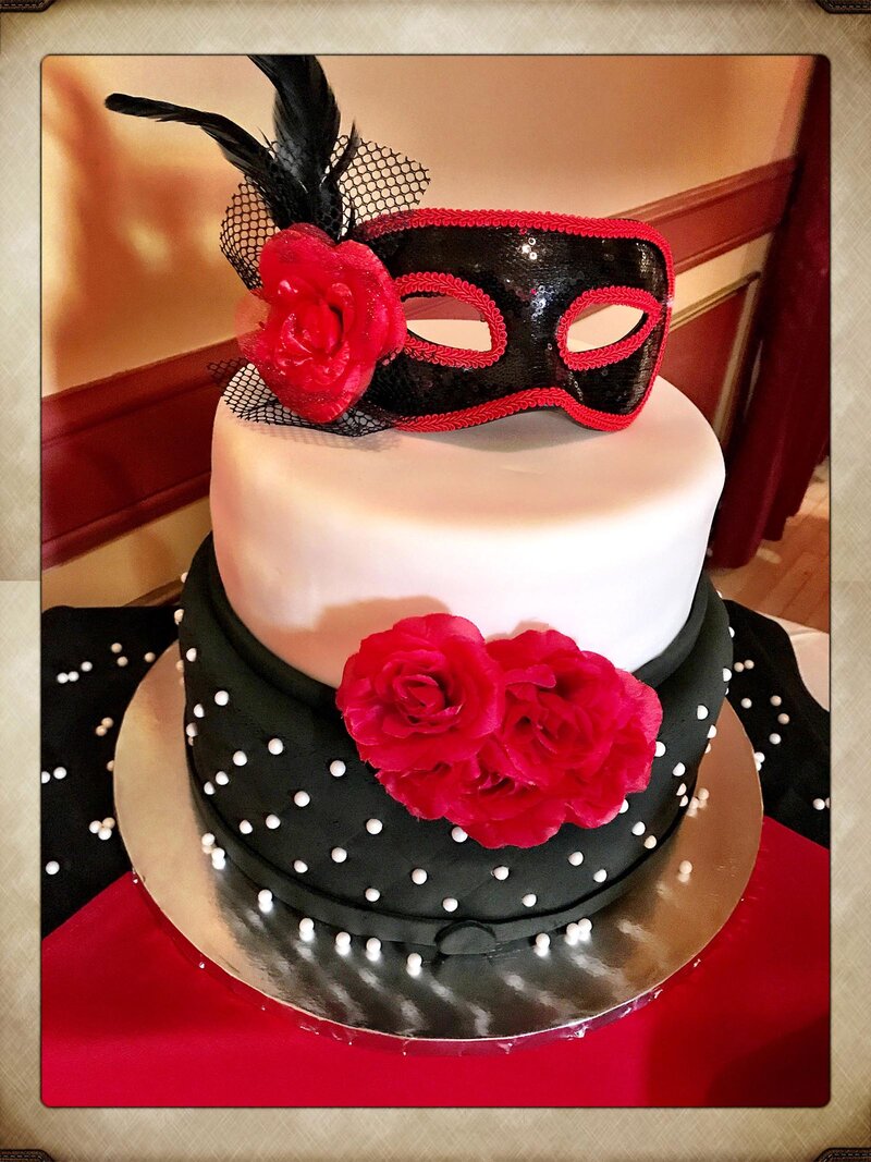 Cake with red flowers and masquerade mask decoration