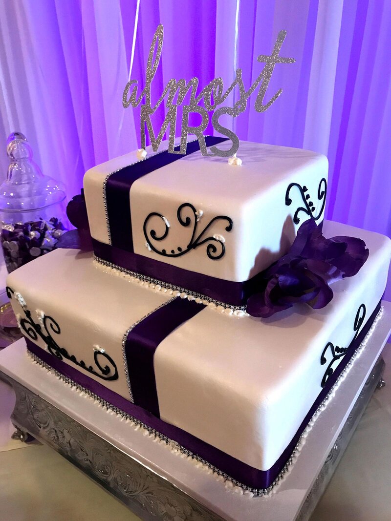 Bridal shower cake with white icing and purple decorations