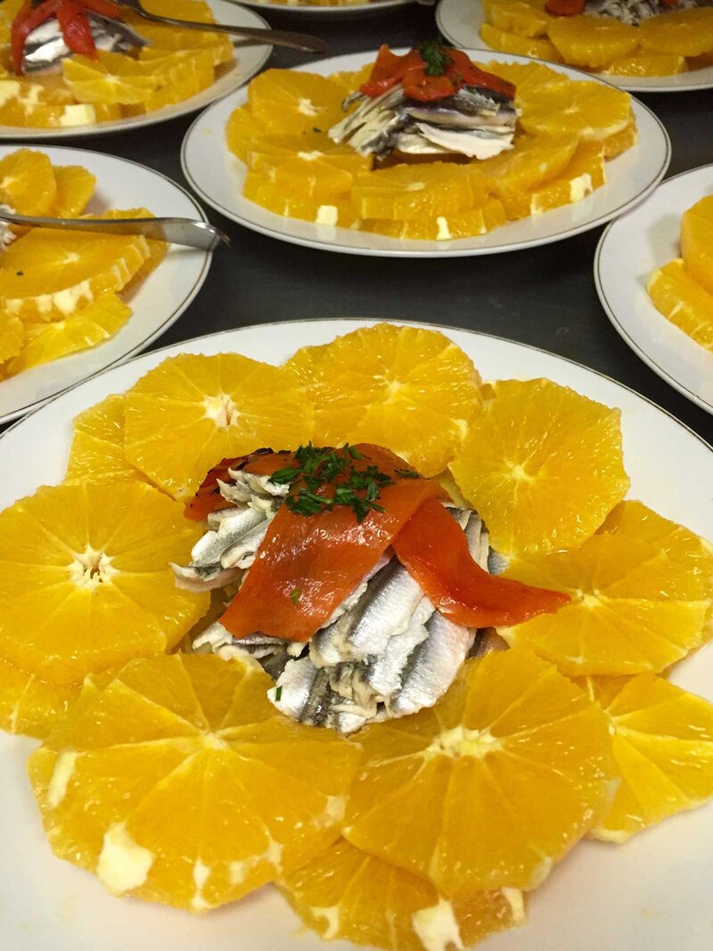 Sliced oranges with roasted red tomatoes and sliced fish
