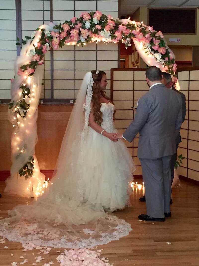 Bride and groom under neath wedding arch