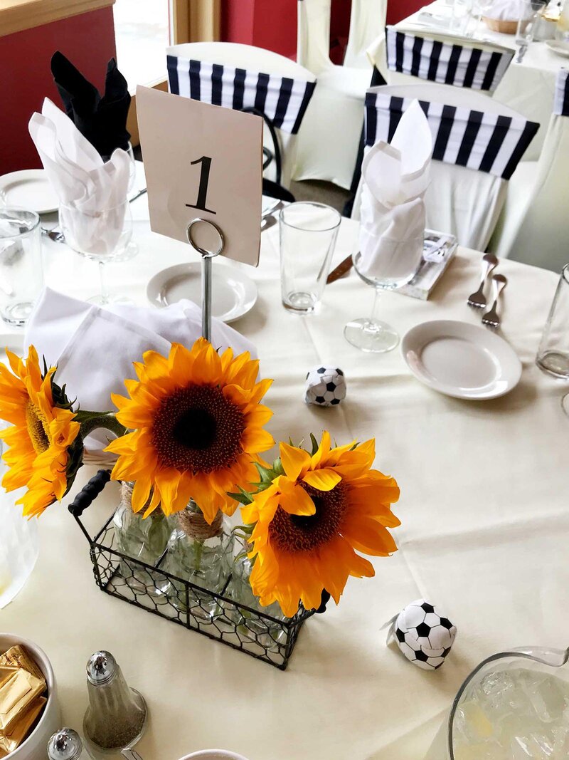 Table with white table cloth and sunflower center piece
