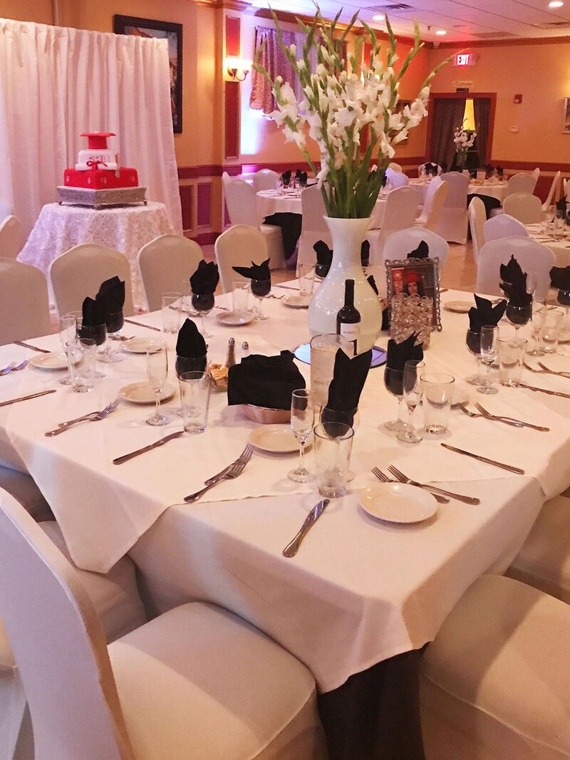 Graduation party table set with white table cloths and black napkins